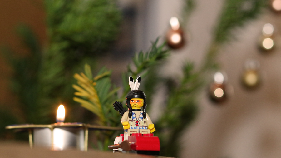 Lego-Indianer als Maskottchen vor weihnachtlichem Hintergrund.